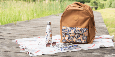 sac à dos marron avec une pochette à fleur sur un ponton