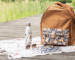 sac à dos marron avec une pochette à fleur sur un ponton